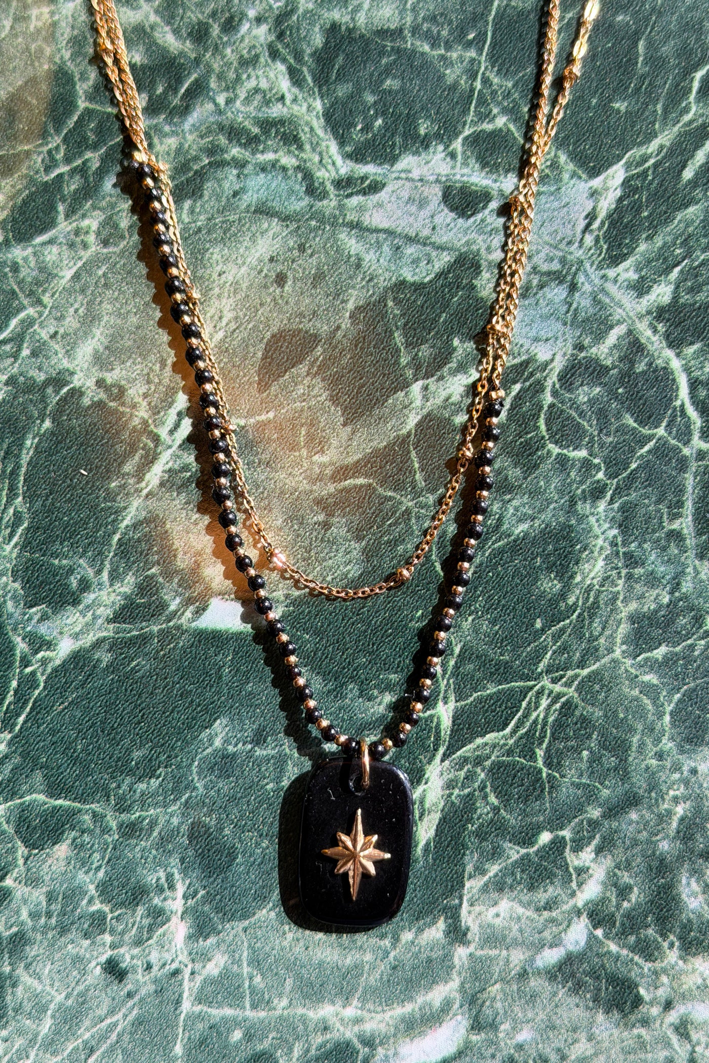 Collier doré double rang perles et pendentif noir petite étoile