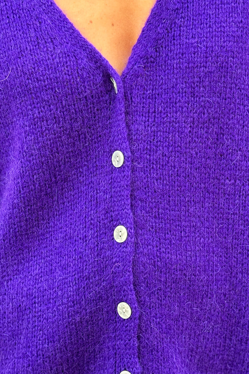 Cárdigan liso de punto morado con pequeños botones de nácar