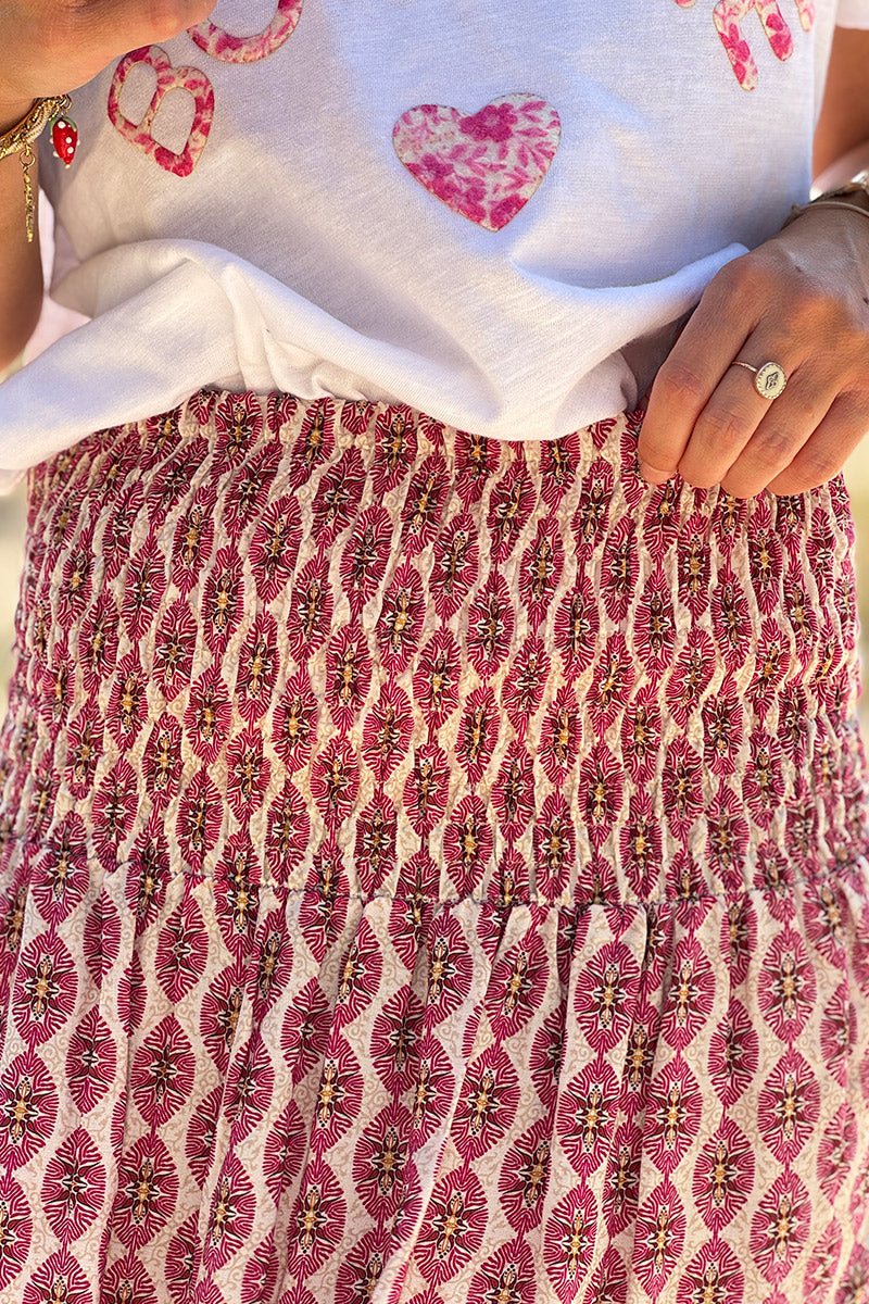 Falda larga y fluida de estilo bohemio con estampado de medallones étnicos fucsia y cinturón fruncido.