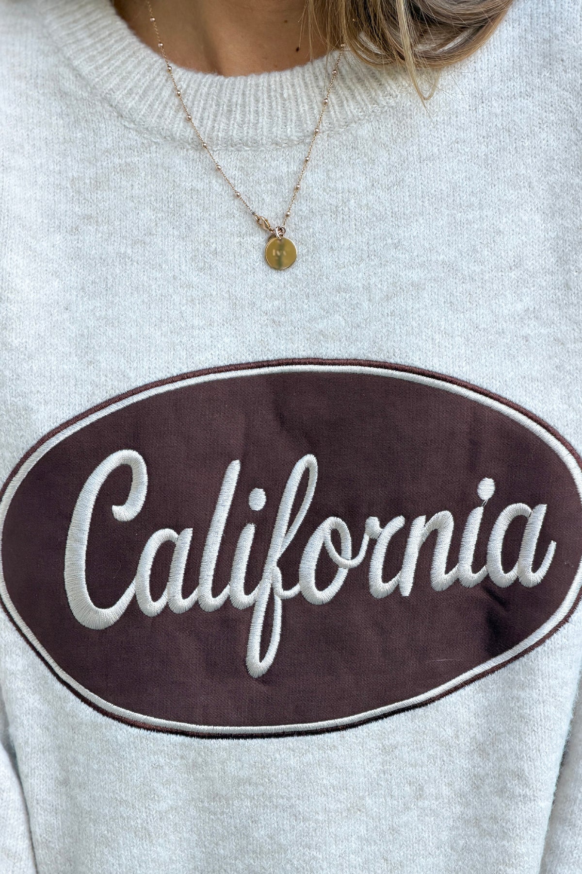 Pull en maille moelleuse beige logo marron California et broderie étoile aux manches