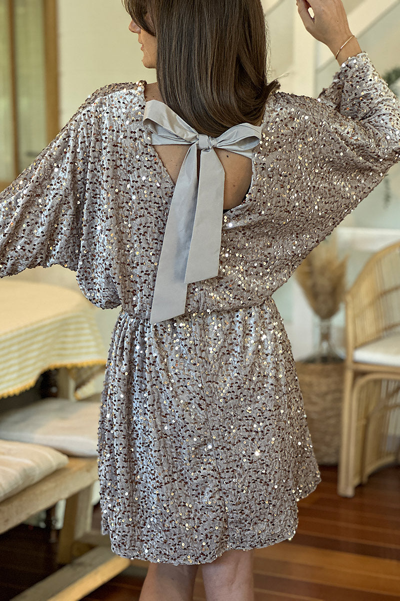 Vestido de terciopelo beige con lentejuelas, escote en pico y lazo en la espalda