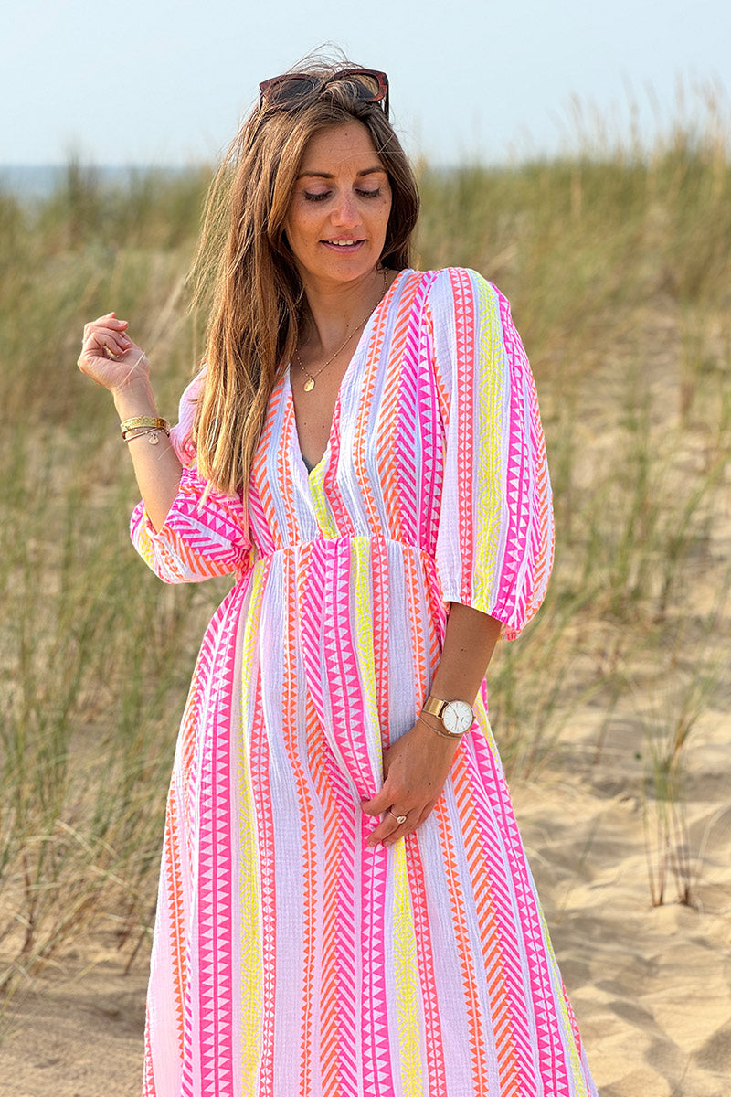 Vestido largo de gasa de algodón con estampado étnico naranja, rosa y amarillo y escote en pico.