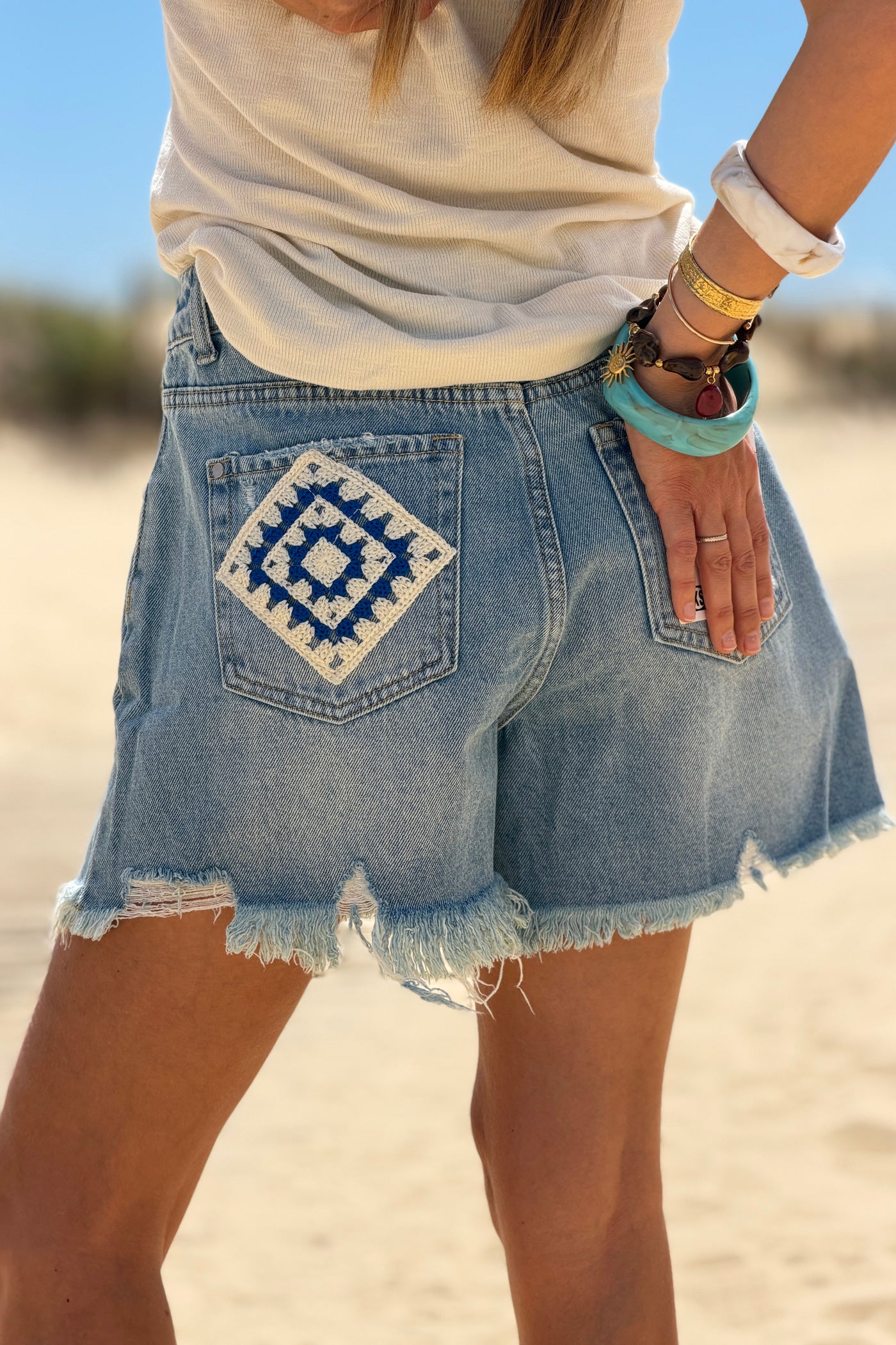 Short en jean delave coupe loose broderie motifs fleurs et patchworks finitions franges