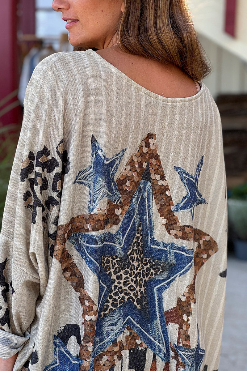 Top beige claro con estampado aleatorio de leopardo y estrellas doradas.