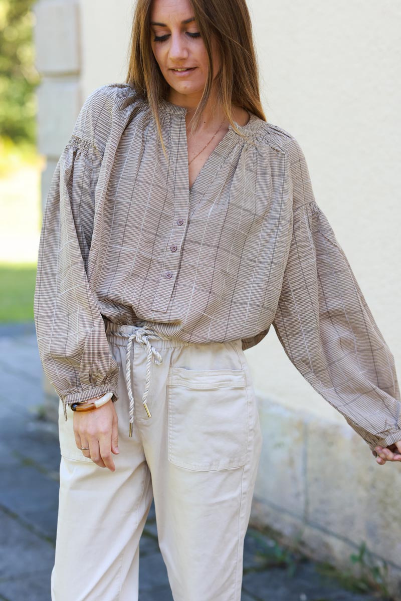 Túnica beige con cuello abotonado y cuadros en relieve de terciopelo.