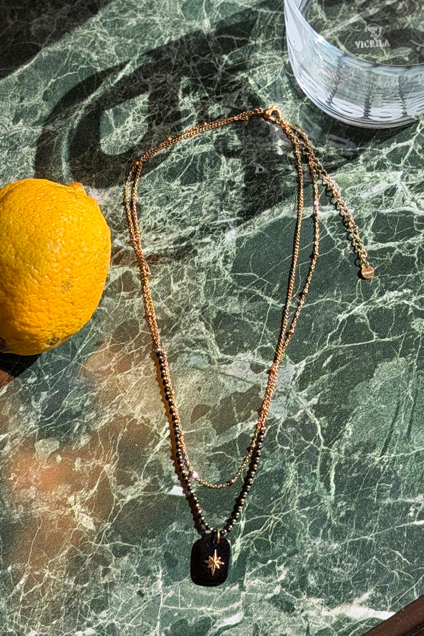 Gold multirow necklace with black beads and rectangle star pendant