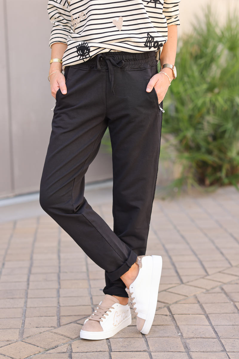 Pantalón deportivo marrón de algodón con cintura elástica y bolsillos con cremallera, ribete bordado en forma de chevrón