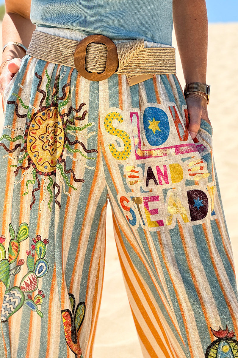 Pantalón ancho brillante, cómodo y flexible con estampado de rayas naranjas y azules de sol y cactus.