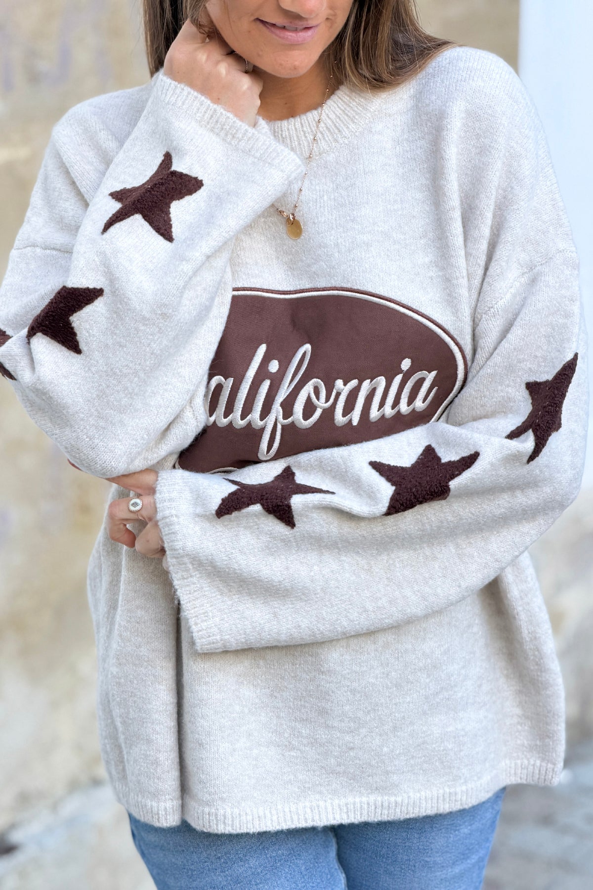 Pull en maille moelleuse beige logo marron California et broderie étoile aux manches