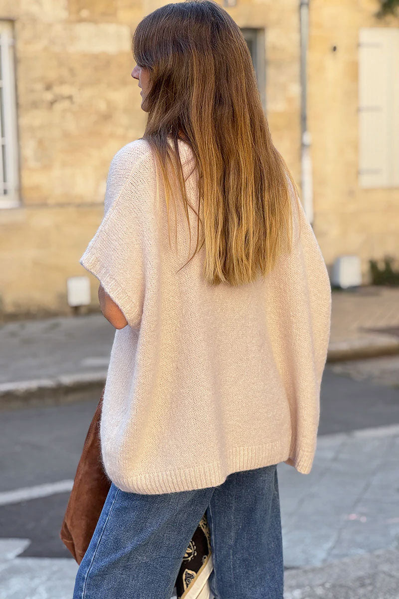 Suéter sin mangas de mohair beige, esponjoso y de gran tamaño, con cuello en V acanalado.