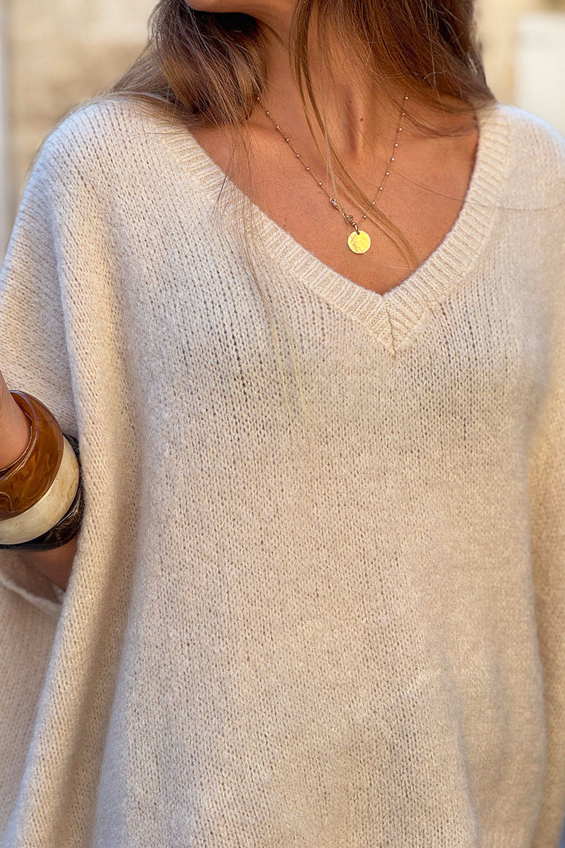 Suéter sin mangas de mohair beige, esponjoso y de gran tamaño, con cuello en V acanalado.
