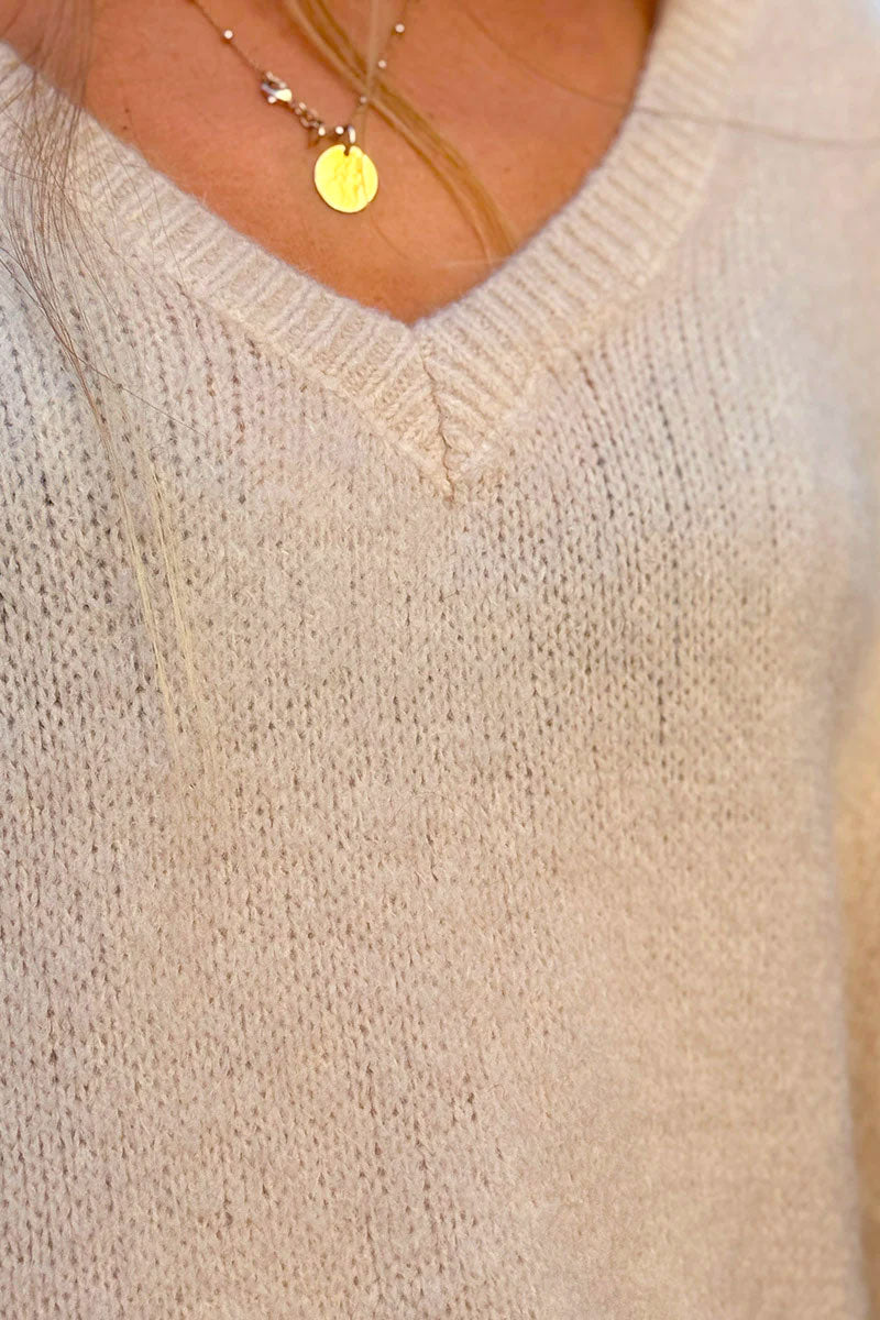 Suéter sin mangas de mohair beige, esponjoso y de gran tamaño, con cuello en V acanalado.