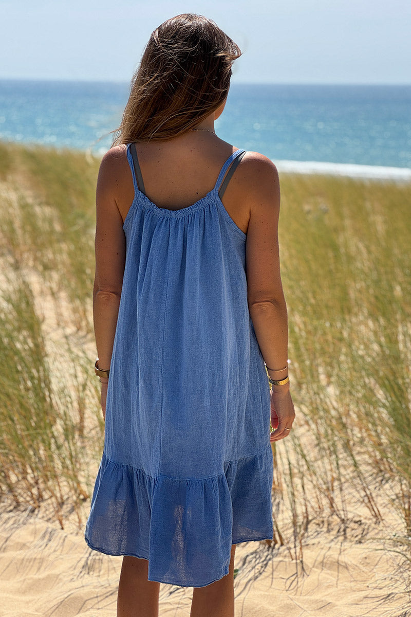 Vestido vaquero azul con tirantes de algodón, cuello elástico y bajo con volantes.