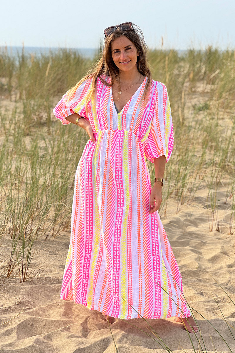 Vestido largo de gasa de algodón con estampado étnico naranja, rosa y amarillo y escote en pico.