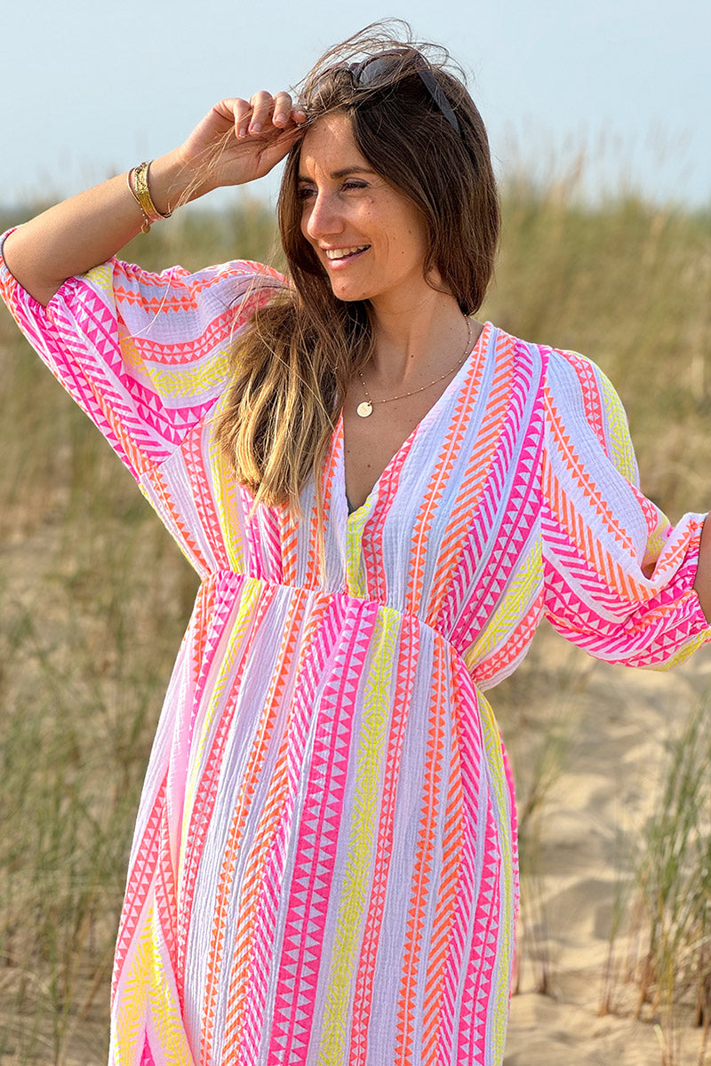 Vestido largo de gasa de algodón con estampado étnico naranja, rosa y amarillo y escote en pico.