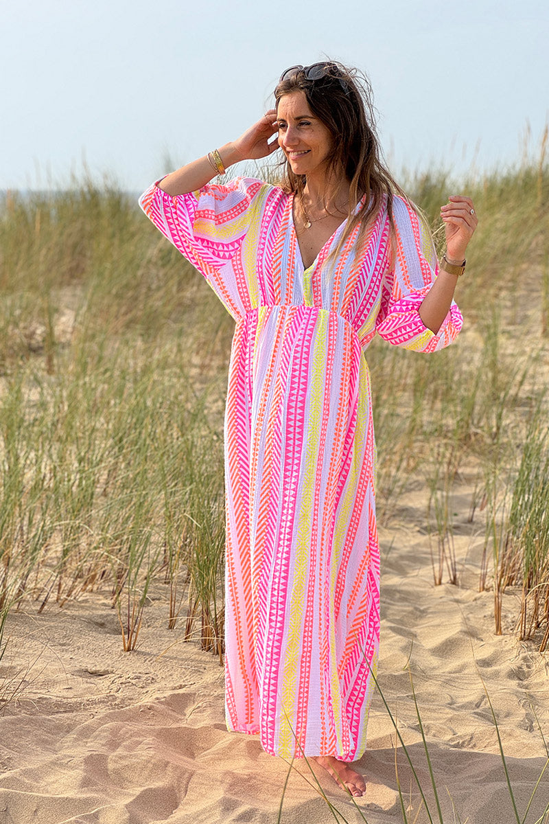 Vestido largo de gasa de algodón con estampado étnico naranja, rosa y amarillo y escote en pico.