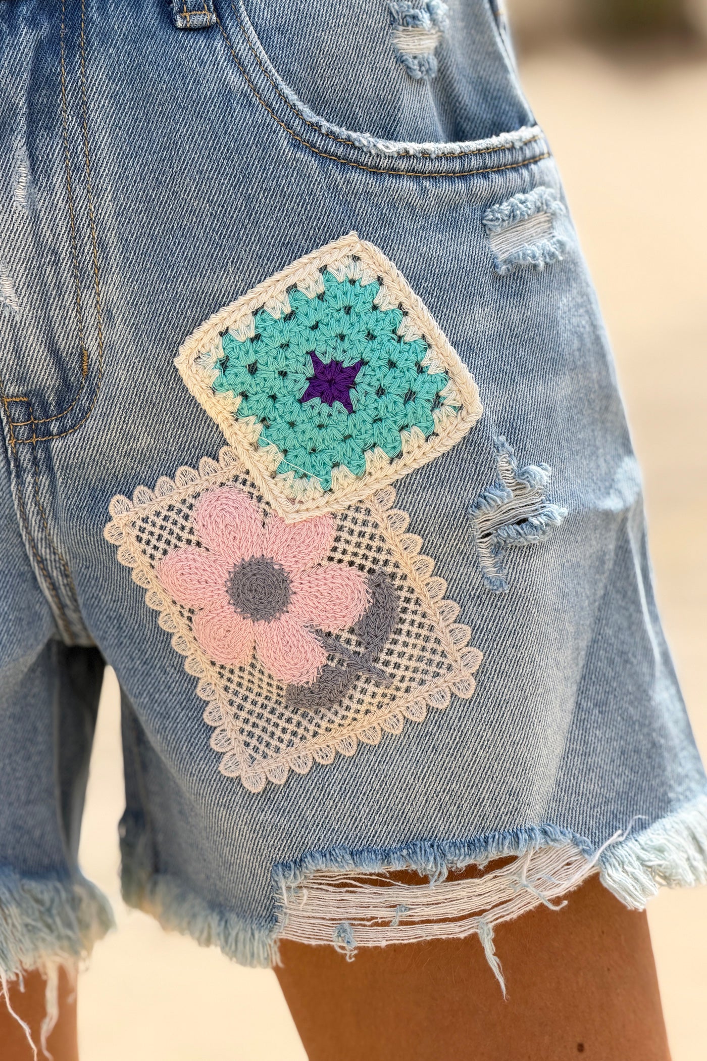 Short en jean delave coupe loose broderie motifs fleurs et patchworks finitions franges