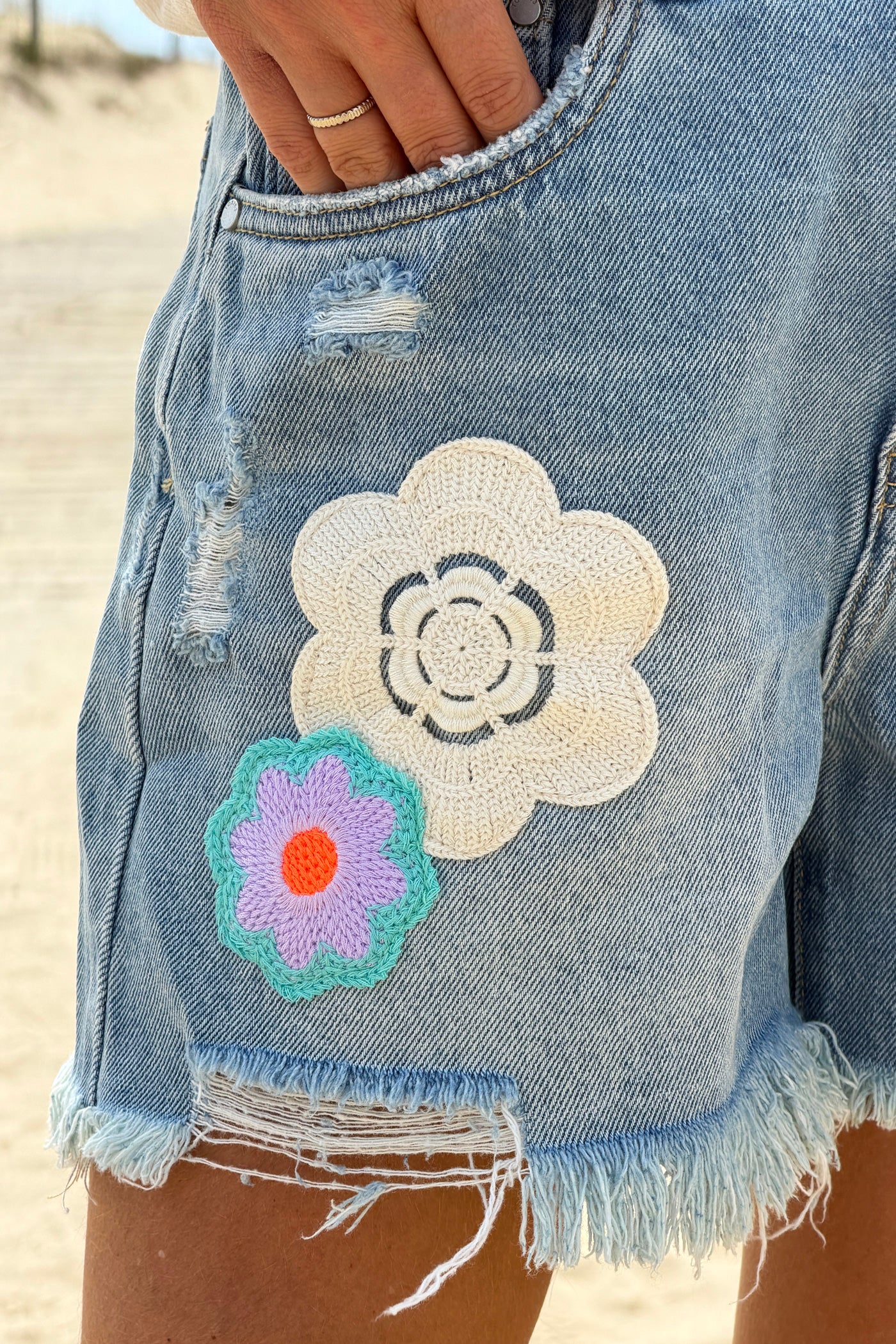 Short en jean delave coupe loose broderie motifs fleurs et patchworks finitions franges