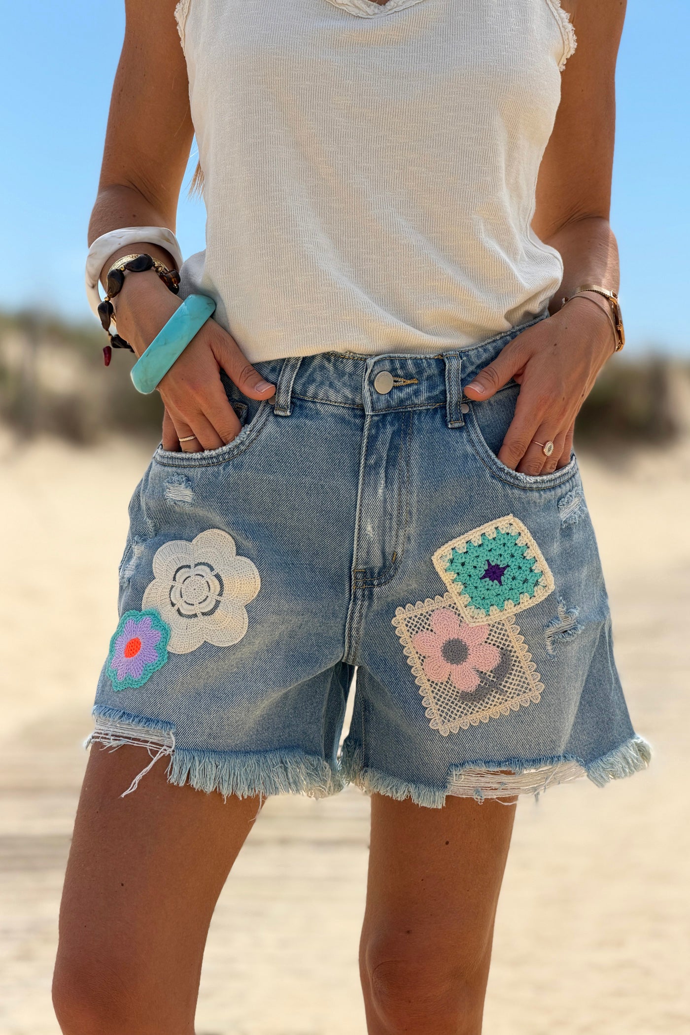 Short en jean delave coupe loose broderie motifs fleurs et patchworks finitions franges