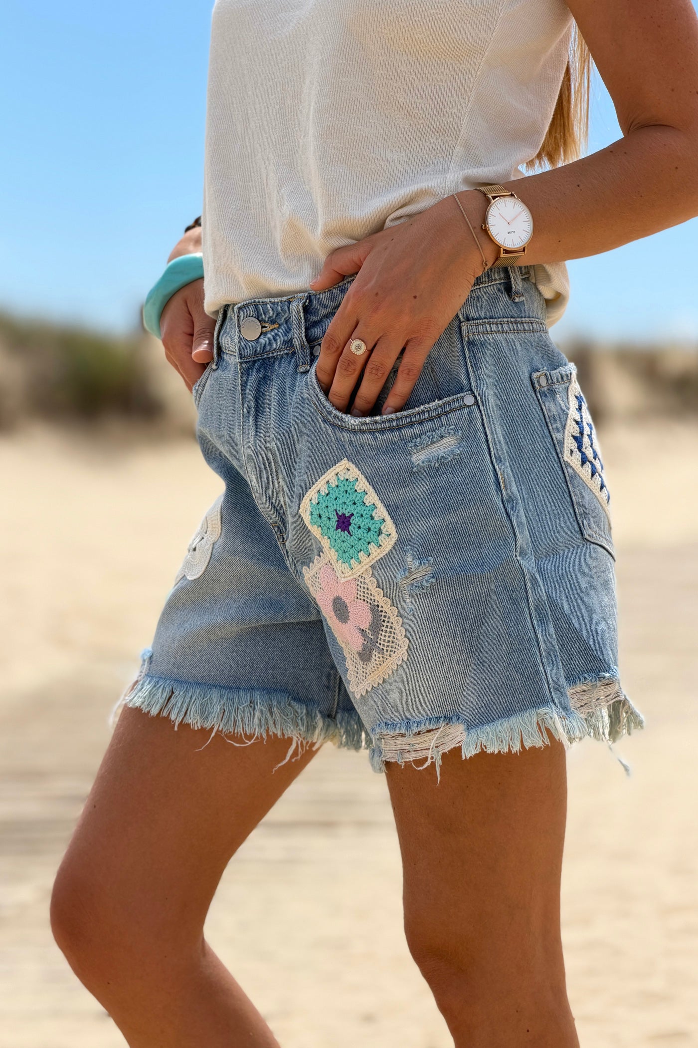 Short en jean delave coupe loose broderie motifs fleurs et patchworks finitions franges