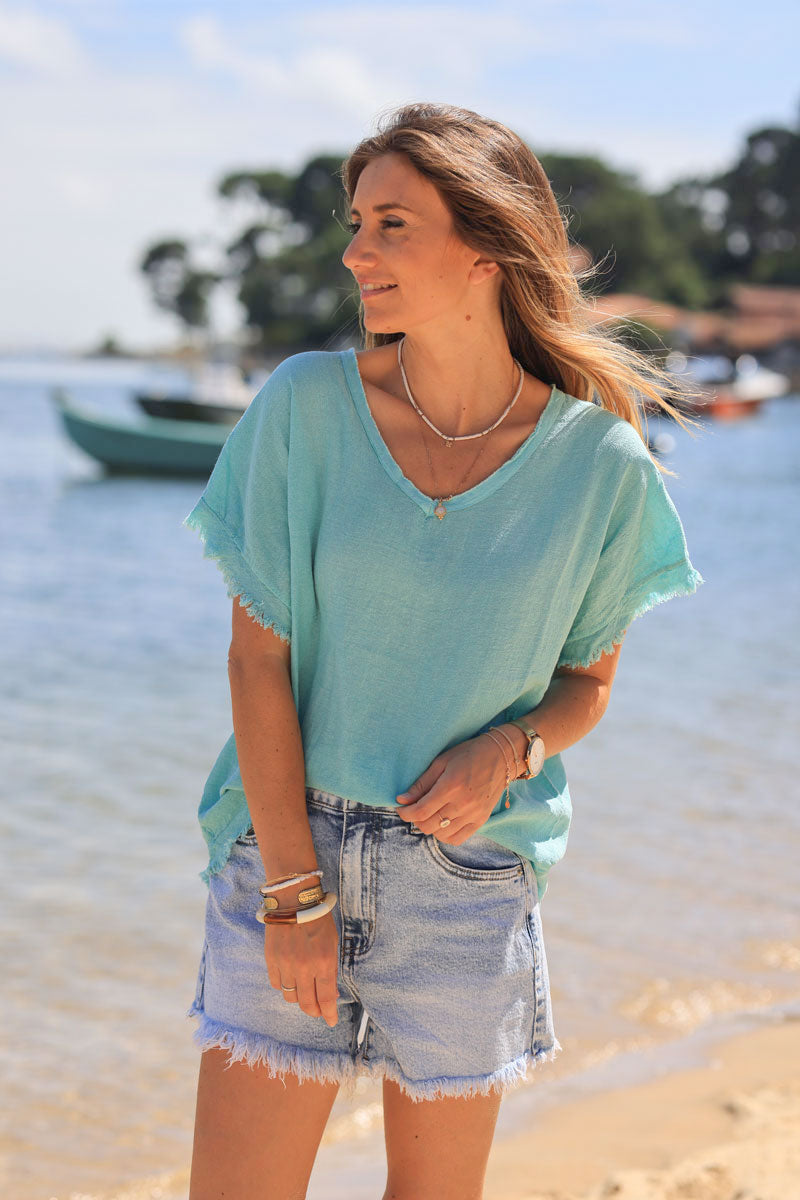 Top turquesa con detalles efecto piqué de algodón y escote en pico con flecos