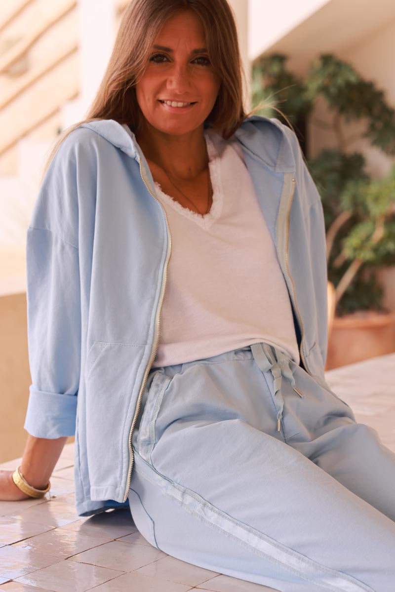 Chaqueta cómoda azul cielo con capucha con cremallera, ribete de cinta de raso y bolsillos.